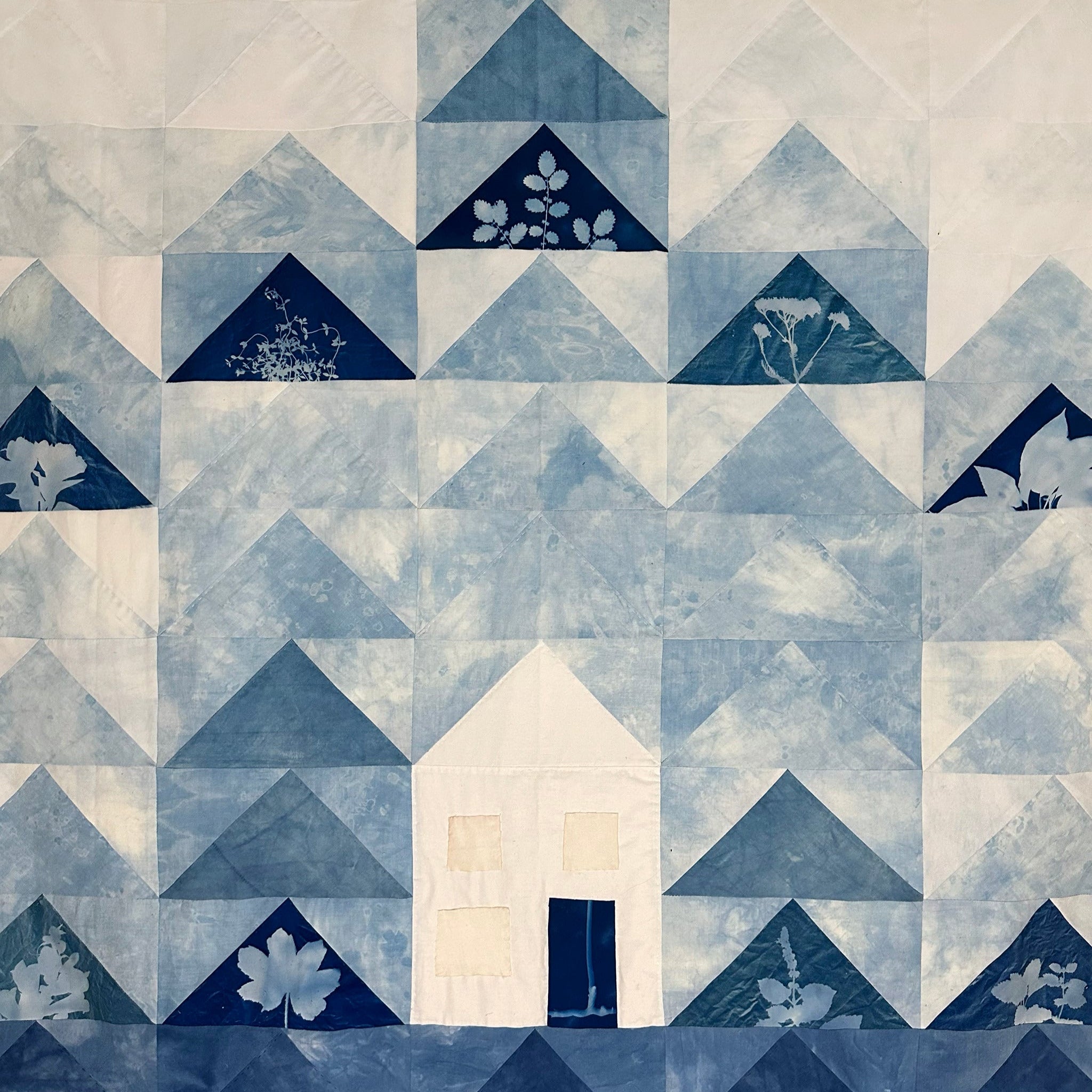 Flock of geese style quilt made with indigo dyed fabric and cyanotypes of herbs for freedom. by lily michaud of brown bear herbs